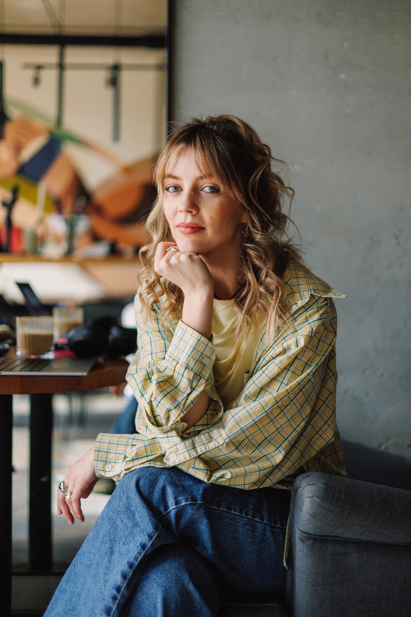 Persona sentada en una cafetería, en un momento de lectura y reflexión